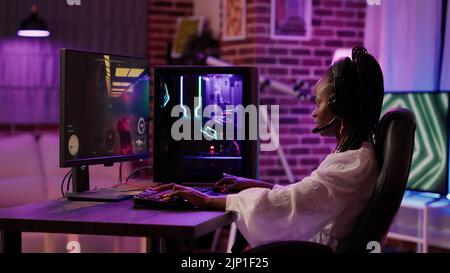 Person Using Gaming Setup Game streamer using pc setup playing multiplayer first person shooter ...