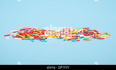 colored sweet sprinkles closeup on blue background. Stock Photo