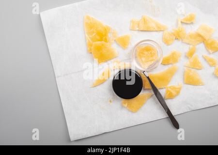 golden pieces wax of cannabis and tweezers on paper, dispensary medical wax with high thc. Stock Photo