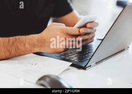 Man Working on the Laptop and Texting with Someone on His Workplace. Body Part. Conceptual Photo of Work Process. Stock Photo