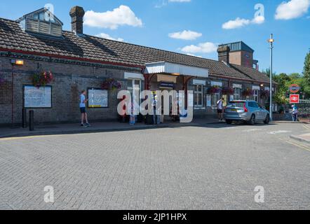 People standing outside Amersham London Underground and National Rail station in Amersham town centre, Buckinghamshire, England, UK. Stock Photo