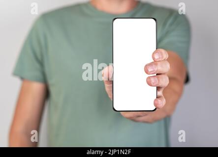 Man holding phone mockup in vertical position. Android with blank display. Person stretching smartphone forward for showing smth. High quality photo Stock Photo