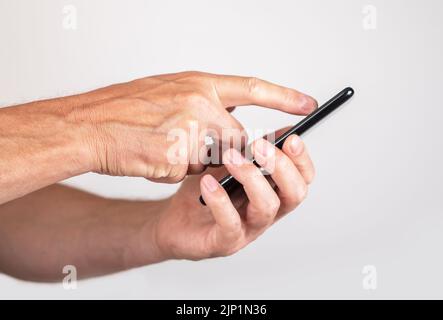 Man forefinger swiping phone screen. Male checking social media, running Internet, scooting through photos, web pages and news articles. High quality photo Stock Photo