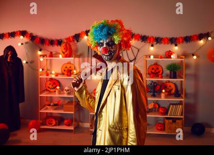 Man clown celebrate Halloween in decorated home Stock Photo