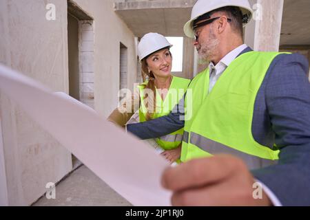 Male foreman is discussing drawing of house with manager Stock Photo