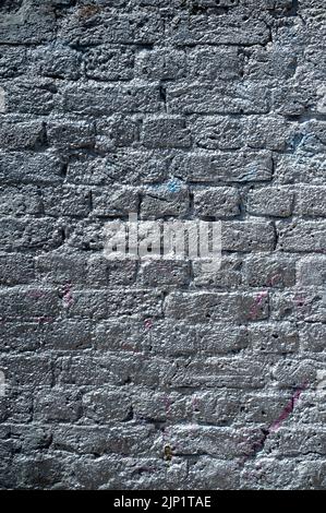 A brick wall sprayed with silver paint. Good for a background or texture Stock Photo