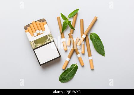 Pack of menthol cigarettes and fresh mint on colored table, Menthol cigarettes top view flat lay. Stock Photo