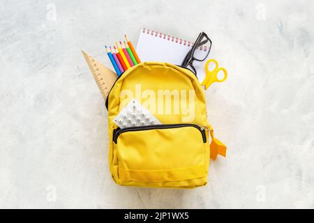 School bag with with colorful school items, top view Stock Photo