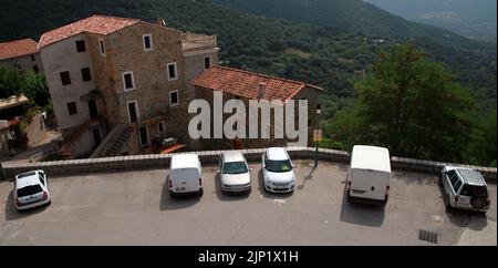 Olmeto, France - August 25, 2018: Street view with parked cars near Church of Santa Maria Assunta of Olmeto, Corse-du-Sud department of France on the Stock Photo