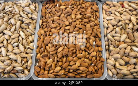 Almond peeled and unpeeled, nuts sales in market. Dry food, variety almonds in store for texture background. Concept of healthy eating, raw product, b Stock Photo