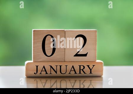 January 2 calendar date text on wooden blocks with blurred background park. Copy space and calendar concept. Stock Photo