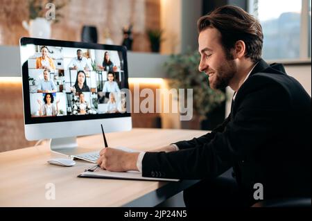 Caucasian business man, conducts a brainstorm with multiracial business team, discussing financial strategy and analyzing risks. Communication by video conference, financial briefing, notes Stock Photo