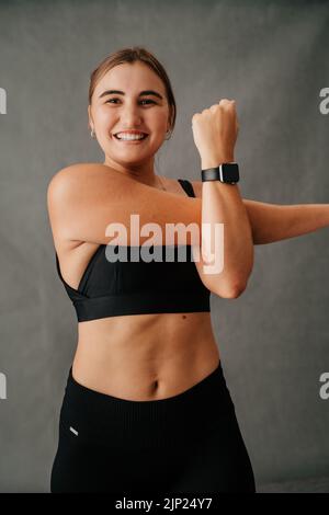 Happy smiling woman doing arm stretching warm up  Stock Photo