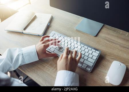 Close up of business woman hands working using keyboard of computer in office workplace Stock Photo