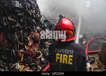 A firefighter tries to extinguish a fire inside the building at a ...
