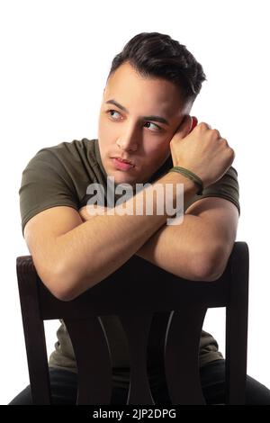 A handsome male sitting on a chair in a studio Stock Photo