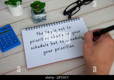 Inspirational quote text on white notepad about priorities and scheduling. Inspirational concept. Stock Photo