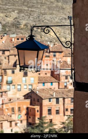 Old lantern on wall on background of village with old stone houses. Albarracin Spain. Stock Photo
