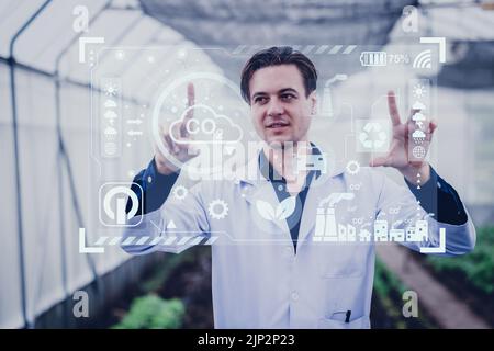 Scientist male researcher looking visual display overlay information data in agriculture farm. Agricultural Science and Technology concept. Stock Photo