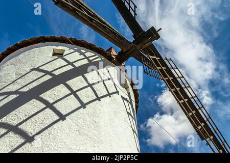 Old white windmills, made of stone, on the field with blue sky and white clouds. La Mancha, Castilla, Spain. Europe. Stock Photo