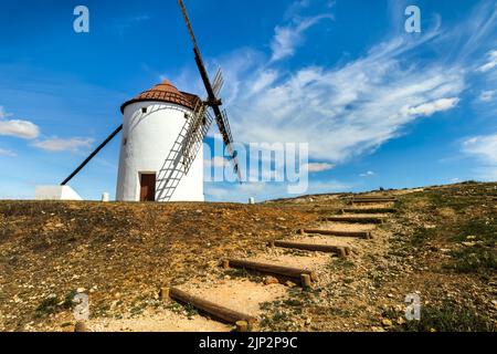 Old white windmills, made of stone, on the field with blue sky and white clouds. La Mancha, Castilla, Spain. Europe, Stock Photo