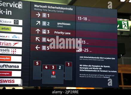 12 August 2022, Brandenburg, Schönefeld: A new type of display board in the main hall of Berlin Brandenburg BER Airport informs passengers about waiting times at various security checkpoints. Photo: Wolfgang Kumm/dpa Stock Photo