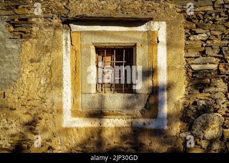 Old window in stone house on the sunny exterior. Spain. Stock Photo