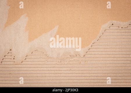 Brown corrugated cardboard with torn edges. Cardboard packaging mesh texture background. Top view, copy space Stock Photo