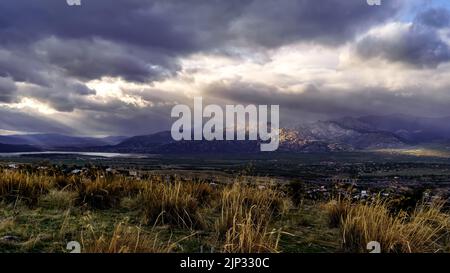 Dramatic storm sky landscape with sun rays between the clouds and over the mountains. Dark landscape. Madrid. Stock Photo