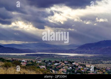 Dramatic storm sky landscape with sun rays between the clouds and over the mountains. Dark landscape. Madrid. Stock Photo
