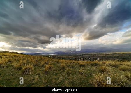 Dramatic storm sky landscape with sun rays between the clouds and over the mountains. Dark landscape. Madrid. Stock Photo