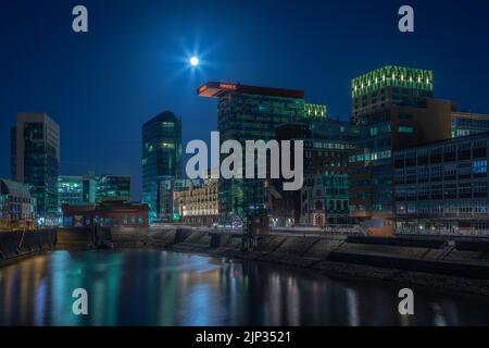 Full moon during blue hour at Media Harbor in Duesseldorf Stock Photo