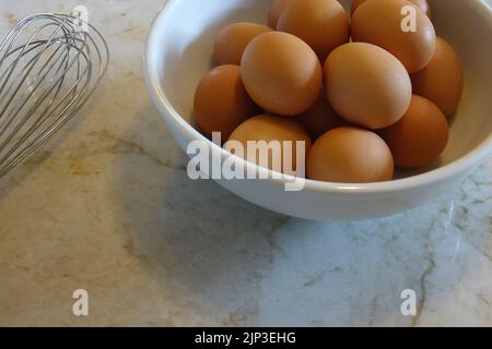 side view of brown eggs in a white bowl Stock Photo