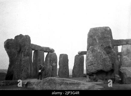 1956, historical, Stonehenge, a prehistoric monument on Salisbury Plain, Wiltshire, England, UK. Picture shows a man standing with shoulder bag by the ancient sarsen stones. Stock Photo