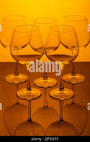 Still life with empty wine glasses on a reflective surface Stock Photo