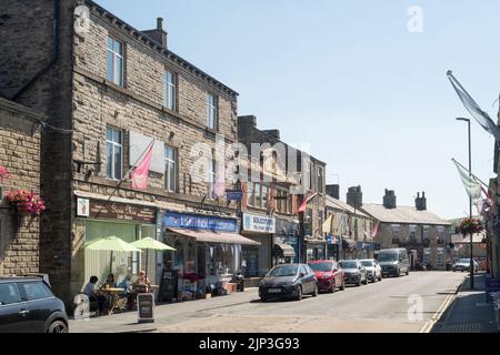 People sat outside café in  Market St, New Mills, Derbyshire, England, UK Stock Photo