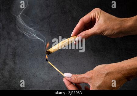 palo santo burning in front of dark background Stock Photo