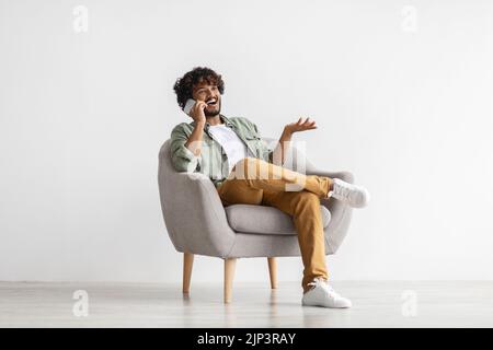 Cool eastern young man having phone conversation Stock Photo