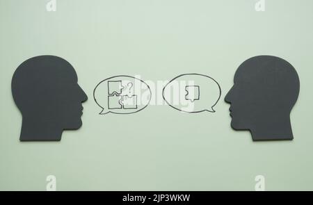 Heads and puzzles in speech bubbles. Leadership and problems solving concept. Stock Photo