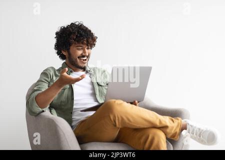 Relaxed eastern guy having video call, using computer Stock Photo