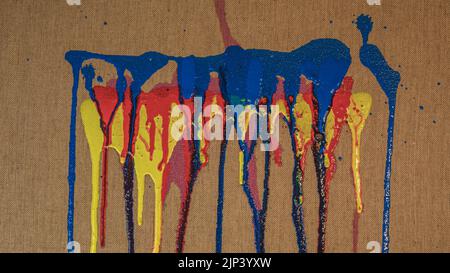Background texture of burlap or canvas fabric closeup with colorful acrylic paint dripping, yellow, red, blue and pink Stock Photo