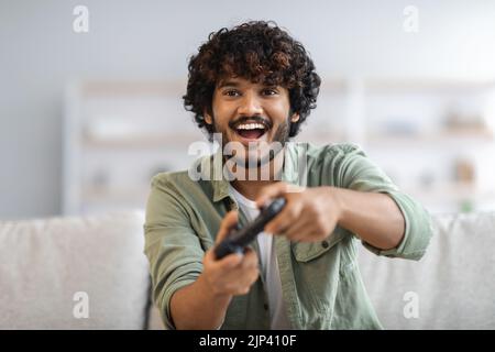 Young happy man laughing and playing video games on weekend Stock Photo