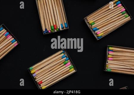 multicolored match sticks in boxes on a black background Stock Photo