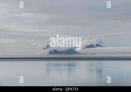 A view from a beach on the South East coast of Iceland at rocks in the clouds. Stock Photo