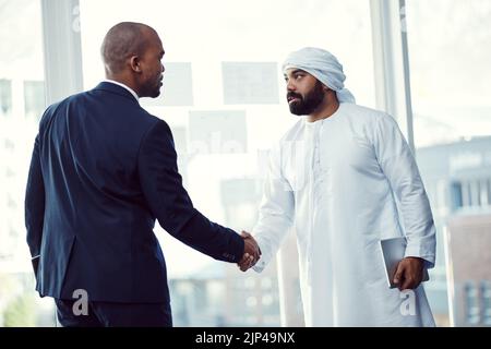 Work with the best, be the best. two businessmen shaking hands in a modern office. Stock Photo