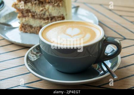 Cup of cappuccino and sweet cake. Delicious morning breakfast. Selective focus on cup. Stock Photo