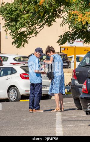 older couple searching through a ladies handbag for something that she has mislaid, lost keys in handbag, husband and wife looking through wifes bag. Stock Photo