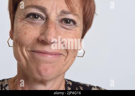 close up of a  middle aged woman smiling on white background Stock Photo