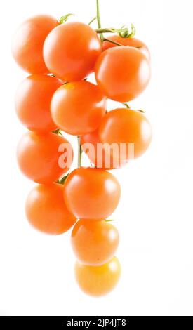 A vertical shot of cluster of red plump cherry tomatoes isolated on white background Stock Photo