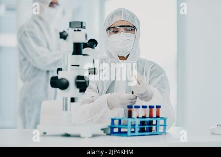 A scientist conducting a medical experiment to research covid vaccine in a lab and collecting blood samples. Healthcare researcher analyzing chemicals Stock Photo